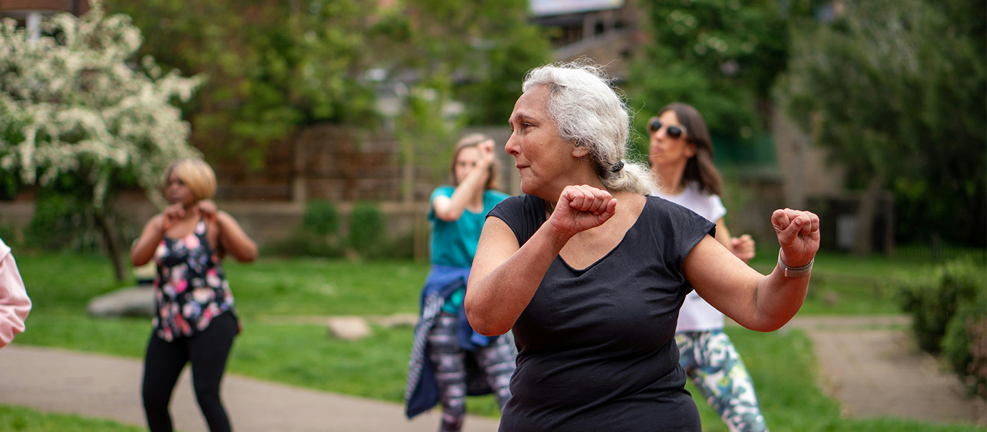 Cheerful, older women exercising outside.
