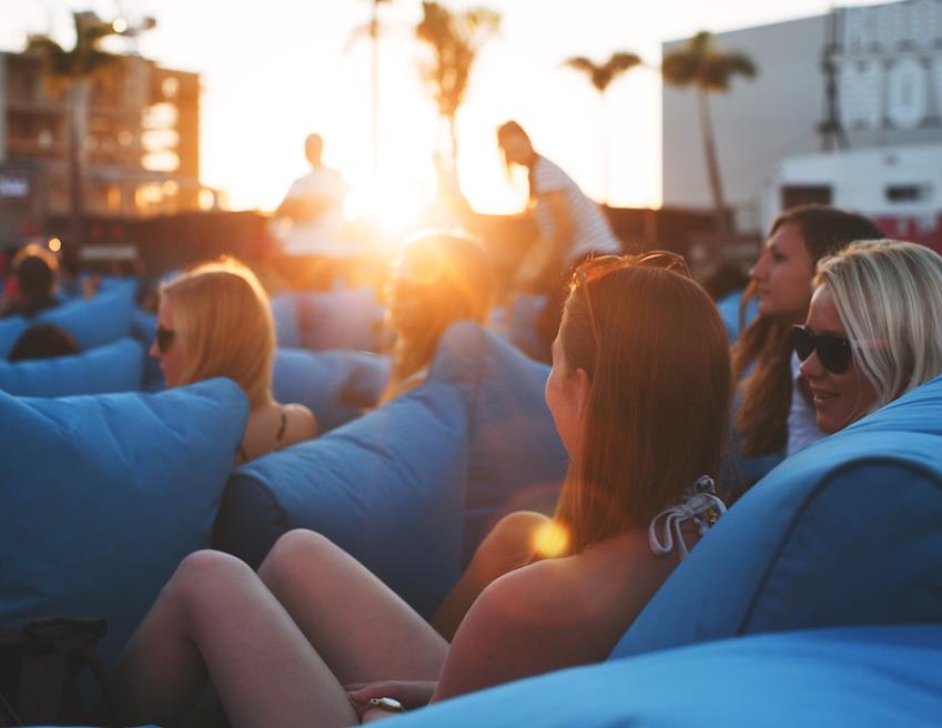People watching a rooftop movie with sunset in background
